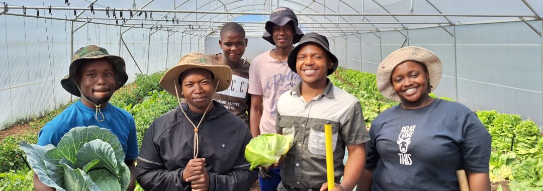 Students in a greenhouse with produce